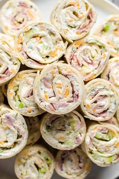 a white plate topped with rolls filled with meat and veggies