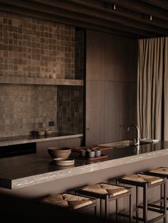 a kitchen counter with stools and bowls on it