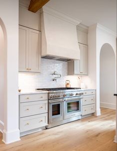 a kitchen with white cabinets and an oven