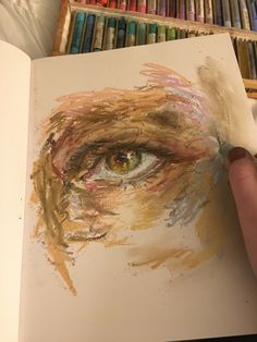 someone is drawing an eye with colored pencils