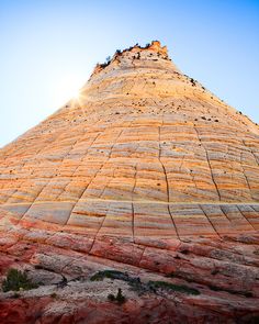 the top of a large rock formation with sun shining on it's face and side