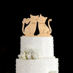 a wedding cake with two cats on top