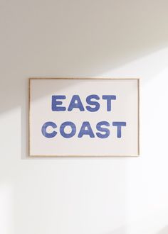 a sign that says east coast hanging on the wall in front of a white wall