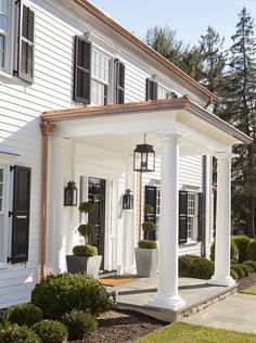 a white house with black shutters and columns