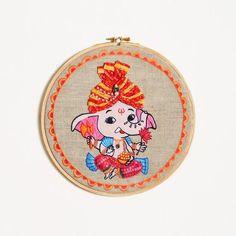 a small embroidered hoop with an elephant on it's face and a red bow around its head