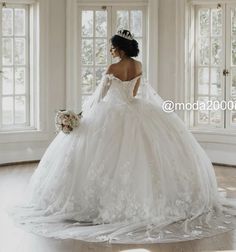 a woman in a white wedding dress looking out the window