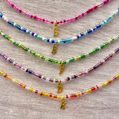 A B O U T - Dainty beaded choker/necklace made with a mix of colorful seed beads. - Carefully crafted to ensure durability so you can wear it everyday. - Personalized with gold initial charm of your choice. - Perfect for layering with other necklaces or chokers, too! - Every single necklace is different and every bead will differ in size and shape. S I Z I N G - Made to order in your specified size. - Finished with an adjustable 1.5" chain extender. - Sizes 12" & 13" fit very close to the neck, Rainbow Letter Beads For Festival, Multicolor Letter Beads Choker With Round Beads, Multicolor Choker With Round Letter Beads, Multicolor Letter Beads Choker, Colorful Choker, Single Necklace, Charm Choker Necklace, Necklace Colorful, Necklace Bead