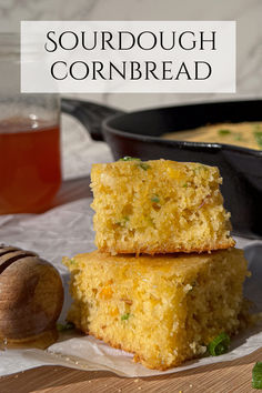 two pieces of cornbread stacked on top of each other next to a bowl of honey