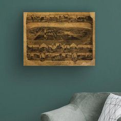 an old map hanging on the wall above a chair in a room with green walls