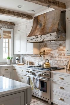 a kitchen with white cabinets and an old fashioned stove top hood over the range,