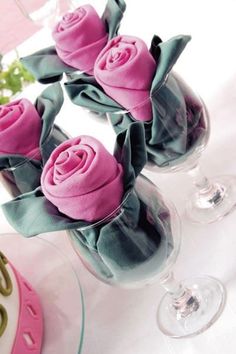 pink roses in glass vases sitting on a table