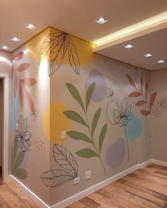 an empty room with painted flowers on the wall and wood flooring in front of it