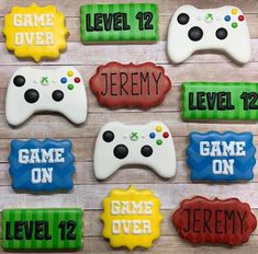 decorated cookies with video game controllers are displayed on a wooden surface, which reads level 12, level 12, level 12, level 12, level 12, level 12, level 12 and level 12