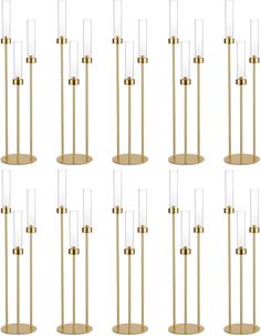 six brass and clear glass floor lamps, each with one bulb on the top in different positions