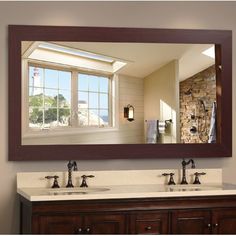 a bathroom vanity with two sinks and a large mirror over the sink in front of it