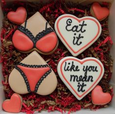 three decorated cookies in a box with the words eat it like you mean it