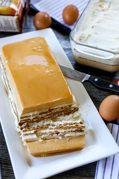 a cake with frosting on a plate next to eggs