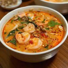 a bowl of soup with shrimp and vegetables