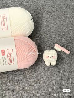 two skeins of yarn next to a toy toothbrush and ball of yarn