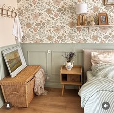 a bed room with a neatly made bed next to a wooden table and shelf on the wall