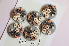 four decorated buttons sitting on top of a card