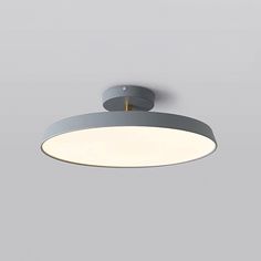 an overhead view of a circular light fixture on a gray wall with white walls and flooring