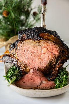 a roast beef on a plate with herbs