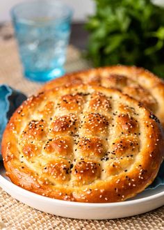 two breads sitting on top of a white plate covered in sesame seed sprinkles