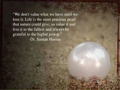 a white ball sitting in the sand with a quote on it