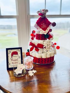 a christmas themed cake sitting on top of a wooden table next to a framed photo