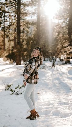 a woman standing in the snow with her hands on her hips