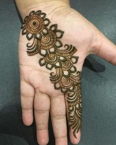 the hand is decorated with henna designs for someone's wedding day or other special occasion