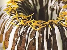 a bundt cake with white icing and orange zest sprinkles