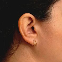 "Introducing our elegant \"Ear Lobe Hugger\" stud earrings, expertly crafted from a single piece of 1mm round wire, delicately looped to embrace your earlobe with style and grace. The Model is wearing a stunning polished brass finish, this minimalist design adds a touch of sophistication to any outfit. The 7mm inner diameter hoop ensures a comfortable fit. Choose from a variety of metals, including brass, copper, bronze, sterling silver, yellow gold filled, rose gold filled, and solid 14k gold. Minimalist Yellow Gold Cartilage Earrings For Anniversary, Minimalist 14k Gold Cartilage Earrings For Anniversary, Minimalist Hypoallergenic Yellow Gold Wrap Earrings, Minimalist Internally Threaded Yellow Gold Hoop Earrings, Classic Hypoallergenic Wrap Earrings As Gift, Classic Hypoallergenic Wrap Earrings For Gift, Classic Hypoallergenic Wrap Earrings, Minimalist Internally Threaded Cartilage Earrings For Anniversary, Minimalist Wrap Earrings For Anniversary