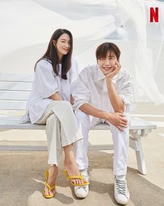 two people are sitting on a bench smiling