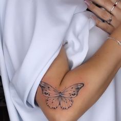 a woman's arm with a butterfly tattoo on the left side of her body