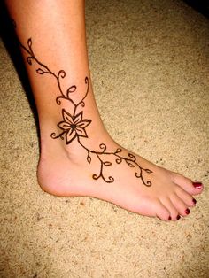 a woman's foot with a flower tattoo on it