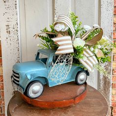 a blue truck with flowers in it on top of a table