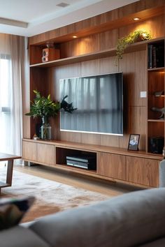 a living room with wooden shelves and a flat screen tv mounted on it's wall