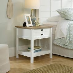 a bedroom with a bed, nightstand and pictures on the side table next to it