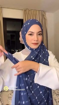 a woman wearing a blue hijab and white shirt