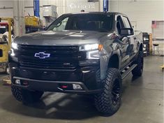 a silver truck parked in a garage next to other vehicles