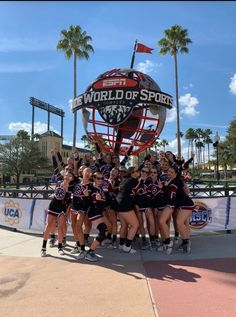 the cheerleaders pose for a photo in front of the world of sport sign