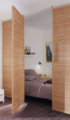 a bedroom with wooden slats on the walls and sliding doors open to reveal a bed