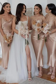 three bridesmaids in champagne colored dresses standing next to each other and holding bouquets