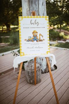 a baby shower sign sitting on top of a wooden easel