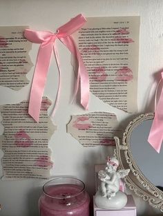 there is a pink candle on the shelf next to a mirror and some paper with writing on it