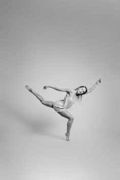 black and white photograph of a woman in the middle of a dance pose with her arms outstretched