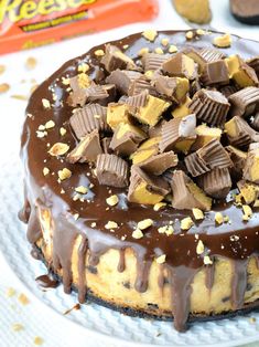 a cake with chocolate frosting and peanut butter pieces on top, next to a bag of reeses