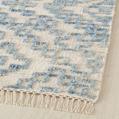 a blue and white rug with fringes on the floor